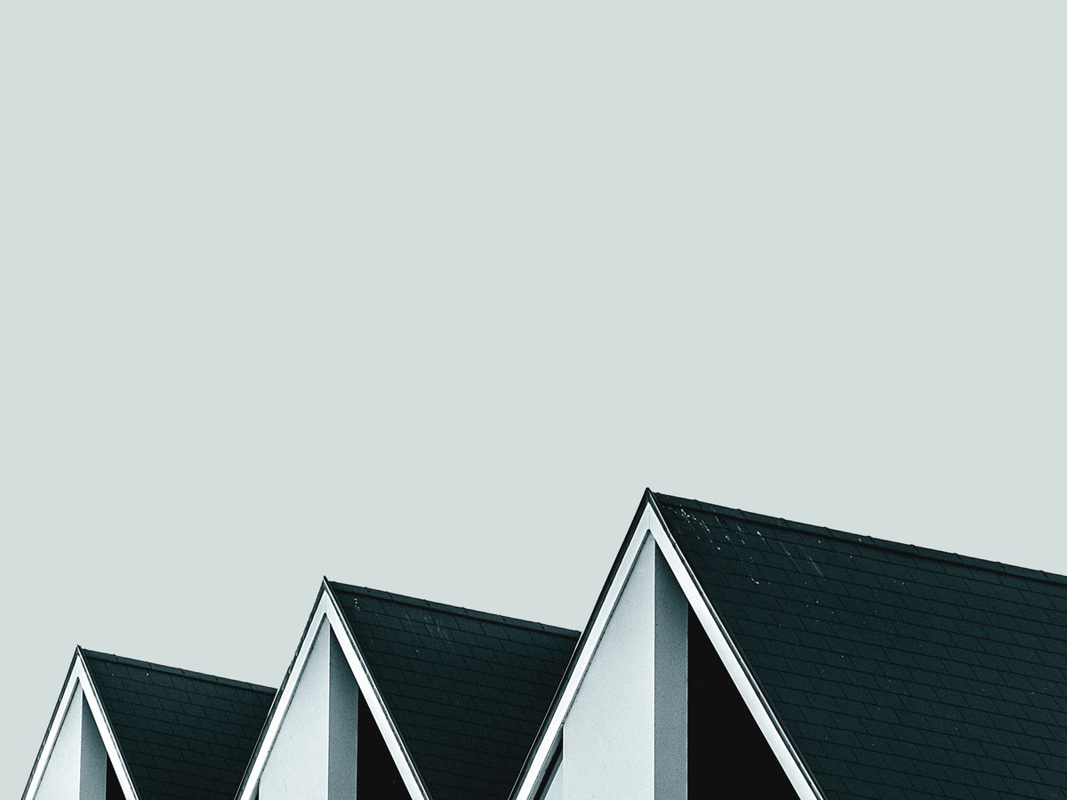Minimalist architectural rooftops against a soft sky.